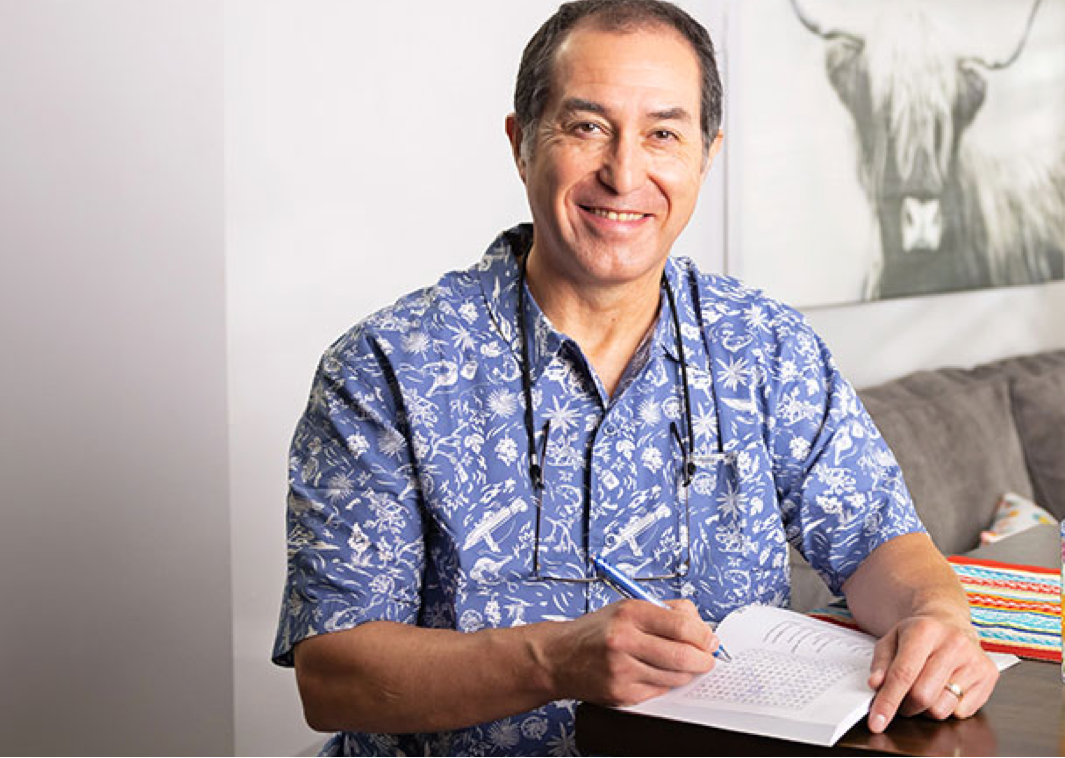 Man sitting at a table in his apartment smiling